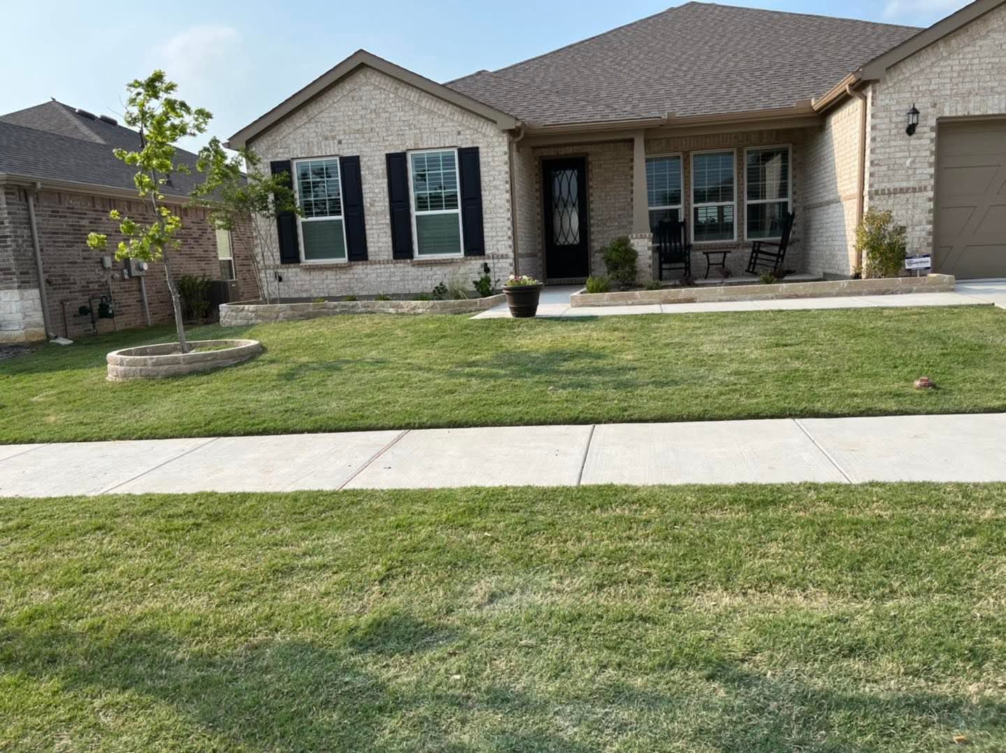 A stone ring around a tree in a front lawn