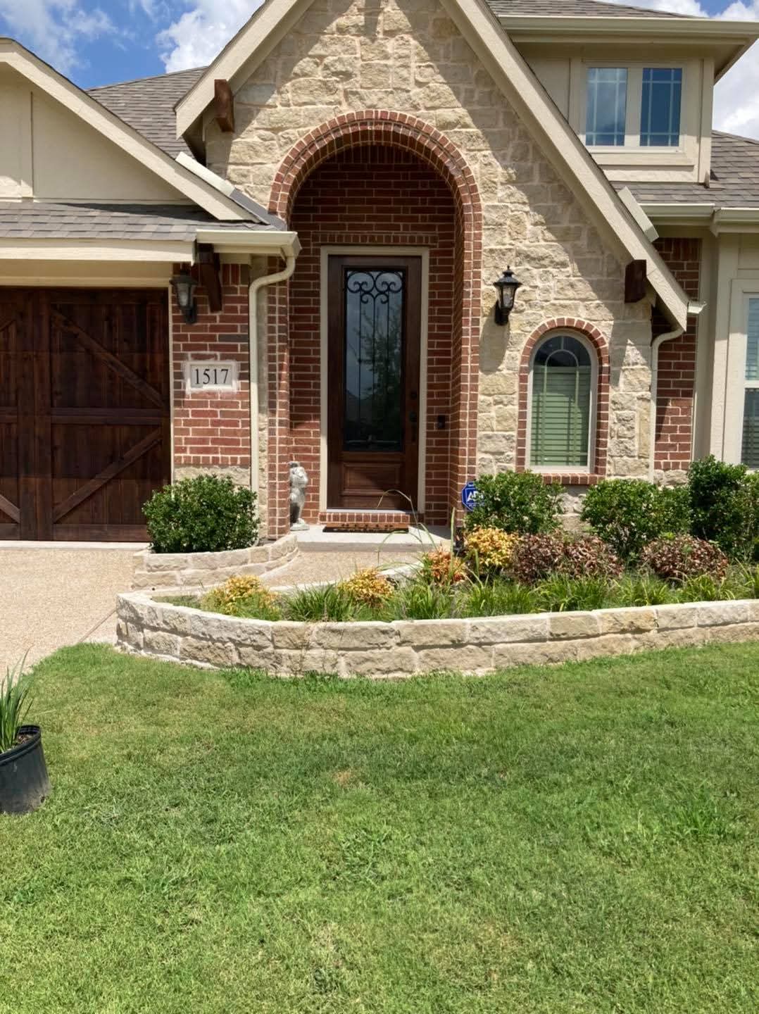 A stone flower bed beside a home’s front entry
