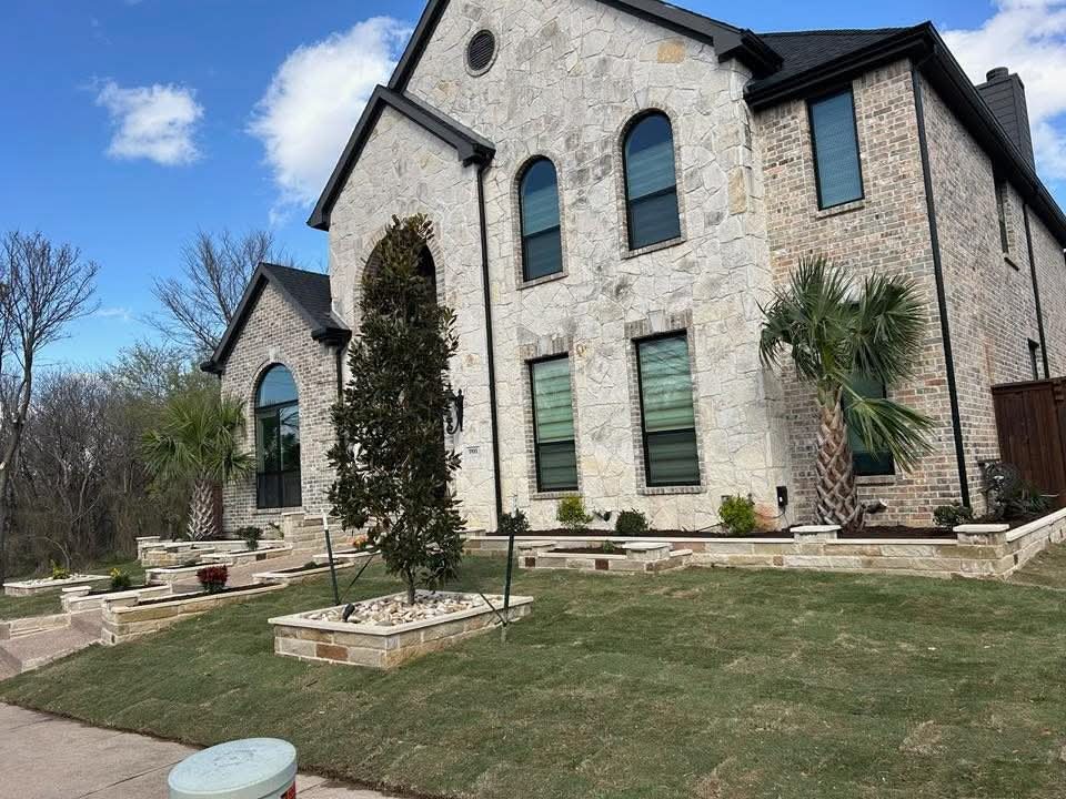 Stone flower beds wrapping a corner home