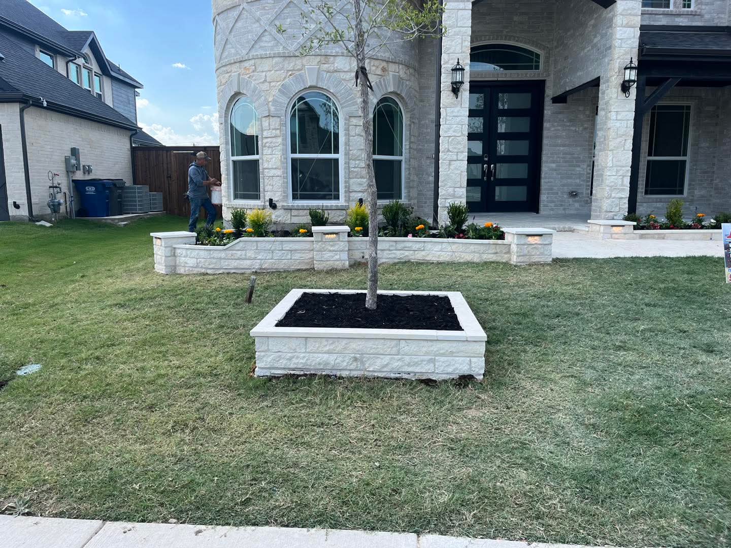 A white stone planter built around a young tree